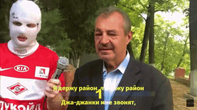 a man in a kia shirt holds a microphone