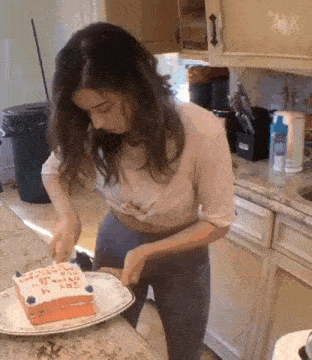 a woman in a kitchen is cutting a cake that says say i love you