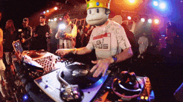 a man wearing a monkey mask is playing a record on a turntable