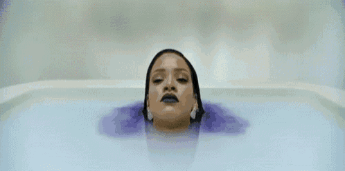 a woman is sitting in a bathtub with the words work , work , work , work