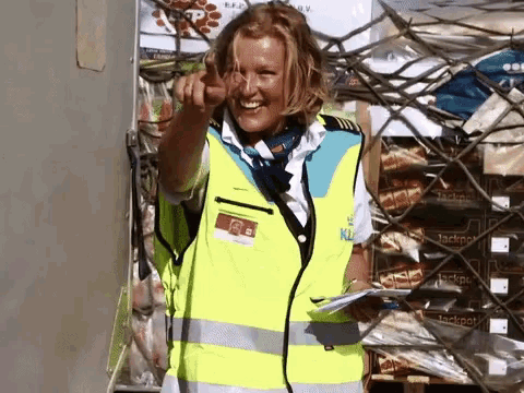 a woman wearing a yellow vest that says ' klm ' on it