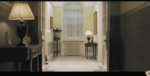 a hallway with two lamps on either side of a table