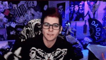 a man wearing glasses and a black shirt with a skeleton on it