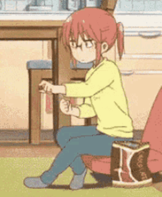 a girl with red hair is sitting on a chair with a box of yogurt .