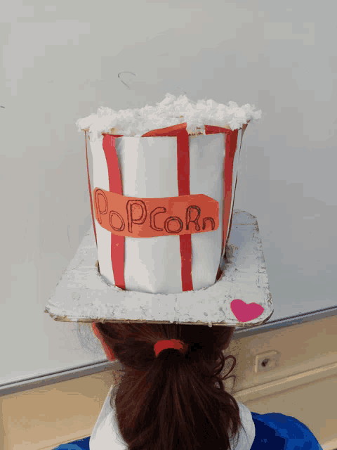 a girl is wearing a hat that says popcorn on it