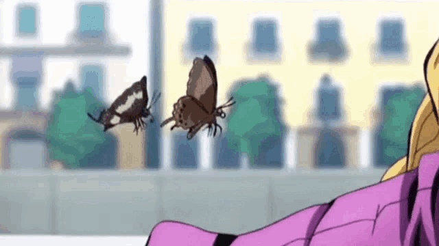 a couple of butterflies are flying over a person 's shoulder .