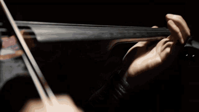 a person playing a violin with a black background
