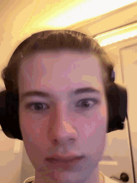 a man wearing headphones looks at the camera