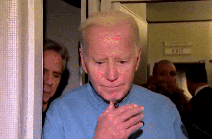 a man in a blue shirt is standing in front of a door that says exit