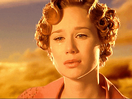 a woman with curlers in her hair is looking at the camera