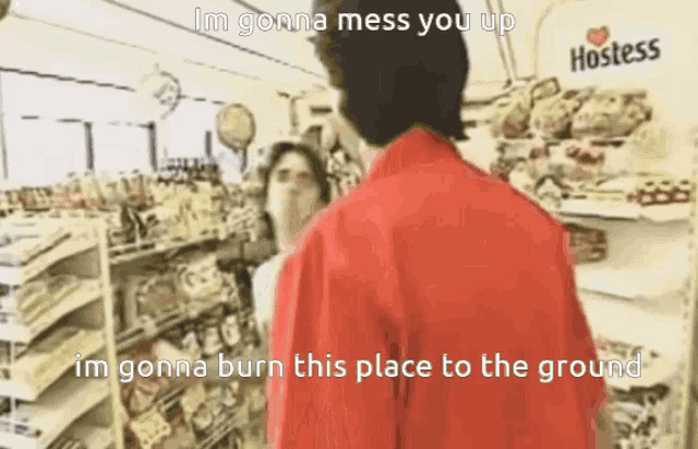 a man in a red jacket is standing in front of a hostess display