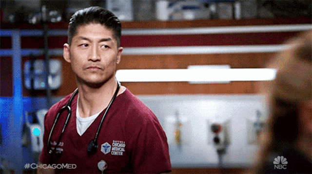 a man with a stethoscope around his neck is wearing a scrub top from the chicago medical center .