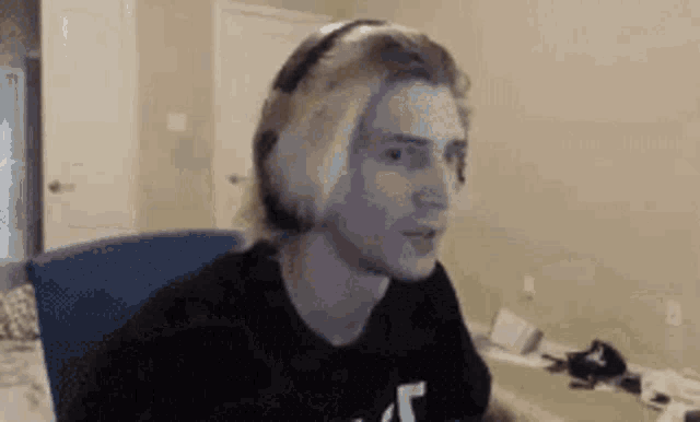 a man wearing headphones is sitting in a chair in front of a computer screen .
