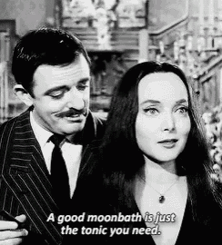 a man and a woman are standing next to each other and the woman is saying a good moonbath is just the tonic you need