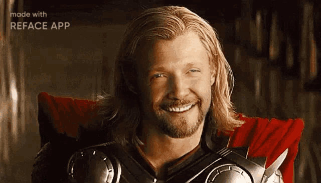 a man with long blonde hair and a beard is smiling while wearing armor .