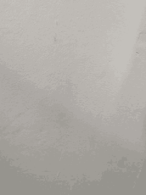 a close up of a white wall with a few small holes
