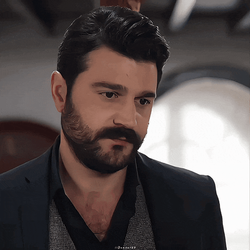 a man with a beard and mustache is wearing a black jacket