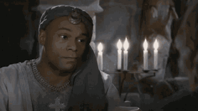 a man is sitting in front of candles and the word sympa is on the bottom