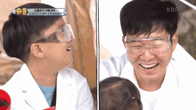 a man wearing a lab coat and goggles is laughing with a baby