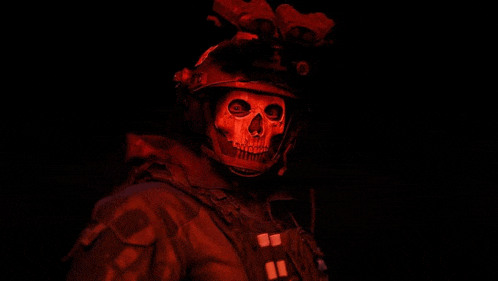 a soldier with a skull mask on his face is wearing a helmet in the dark .