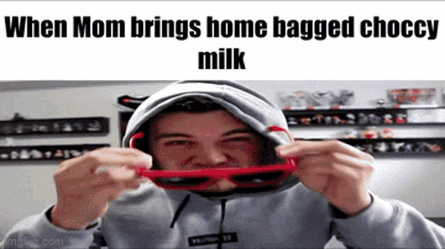 a man wearing a hoodie and sunglasses with the words when mom brings home bagged choccy milk on the bottom