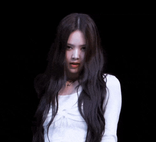 a woman with long hair and a white tank top
