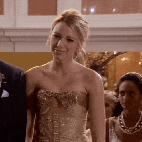 a woman wearing a strapless gold dress with a bow