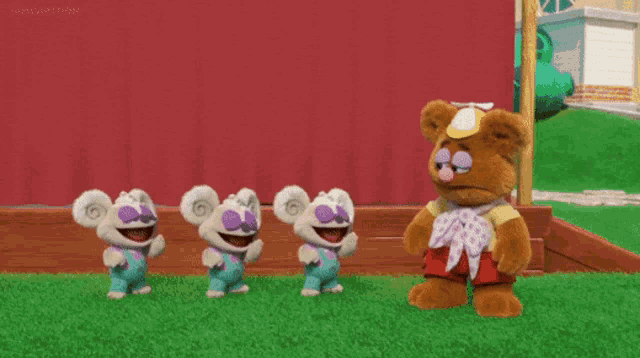 three stuffed animals are standing next to each other and one of them is wearing overalls with the letter a on them