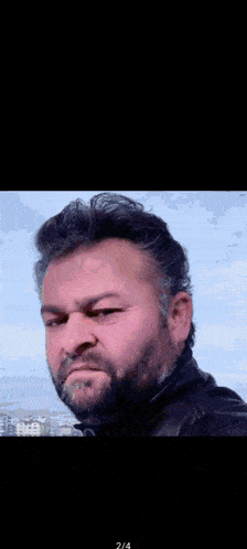 a man with a beard and a red letter k on his neck