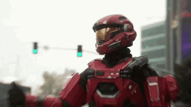 a man in a red helmet is standing in front of a traffic light