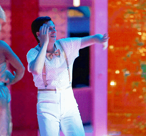 a man wearing suspenders and a bow tie is dancing on a stage