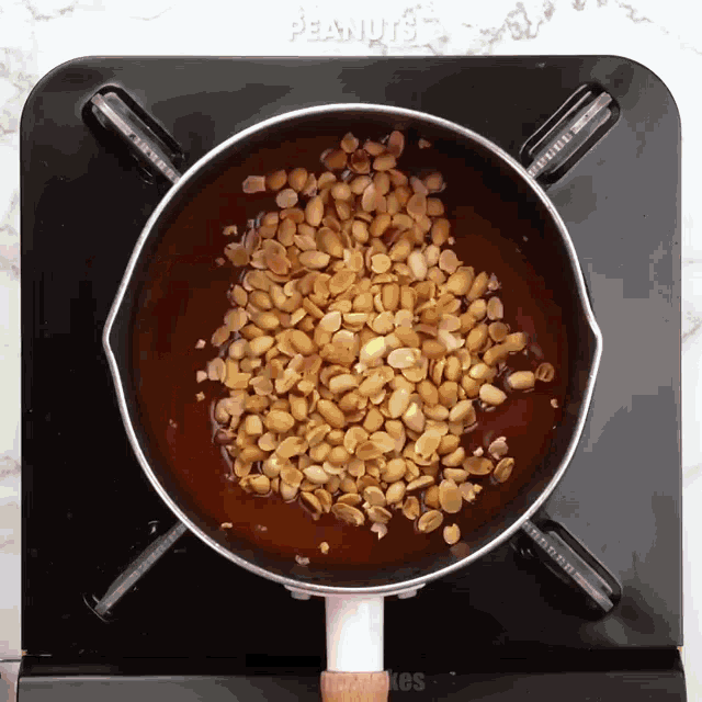a pot of peanuts is being cooked on a stove
