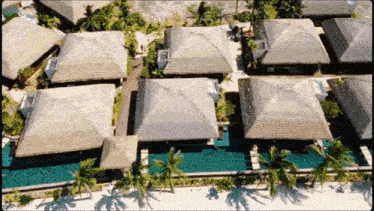 an aerial view of a tropical resort with thatched roofs