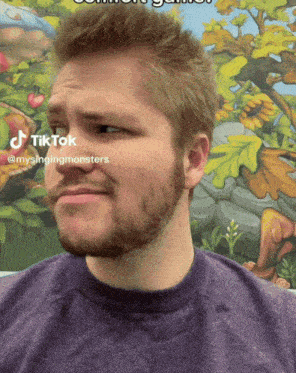 a man with a beard is wearing a purple sweater and has a tiktok icon on his face