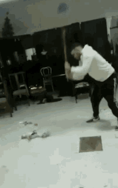 a man is holding a large hammer in a living room .