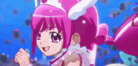 a girl with pink hair and a crown on her head is standing in the water .