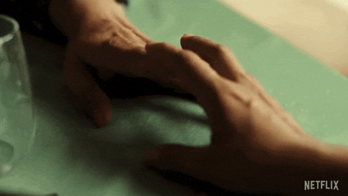 a close up of a person holding another person 's hand with the netflix logo visible