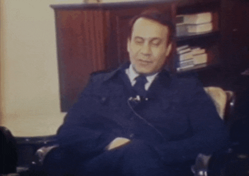 a man in a suit and tie sitting in a chair