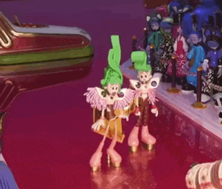 a couple of dolls standing on a red surface
