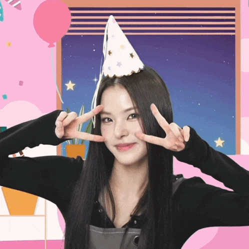 a woman wearing a party hat is giving a peace sign