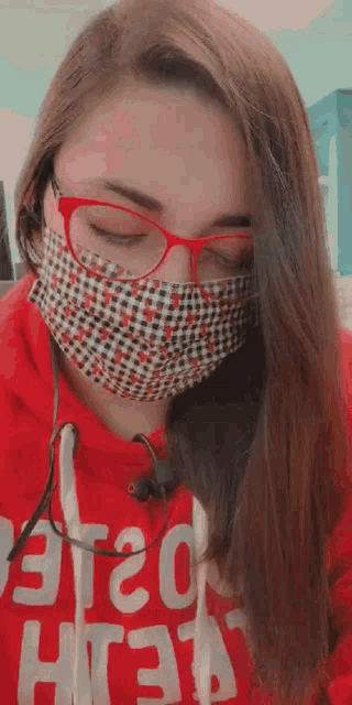a woman wearing glasses and a face mask is wearing a red hoodie with the word aeropostale on it