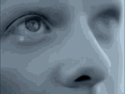 a close up of a woman 's eye and nose with a tear coming out of it .
