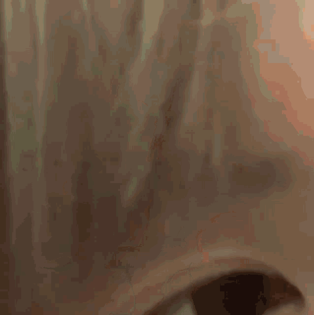 a close up of a person wearing a mask and looking at the camera .