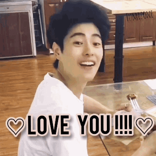 a young man sitting at a table with a fork in his hand and the words love you
