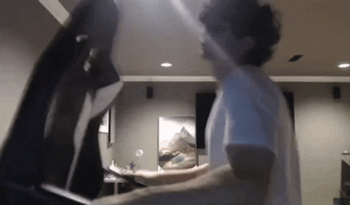 two men are standing next to each other in a room .