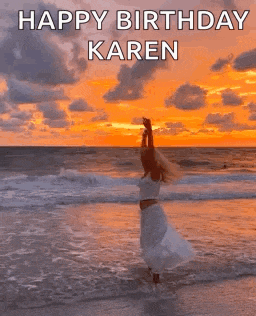 a woman is standing on the beach at sunset with her arms outstretched .