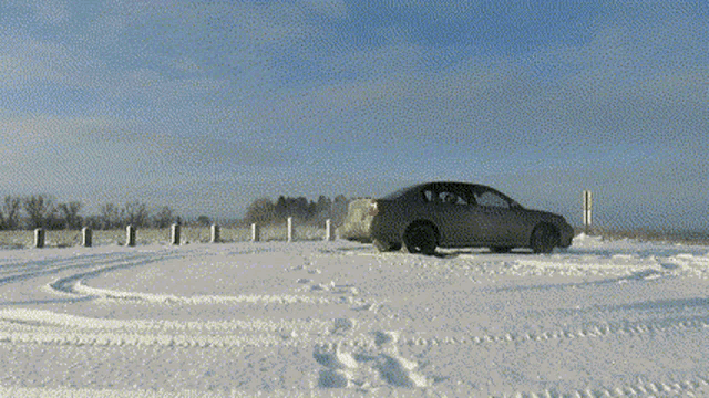 a car is parked in the snow near a sign