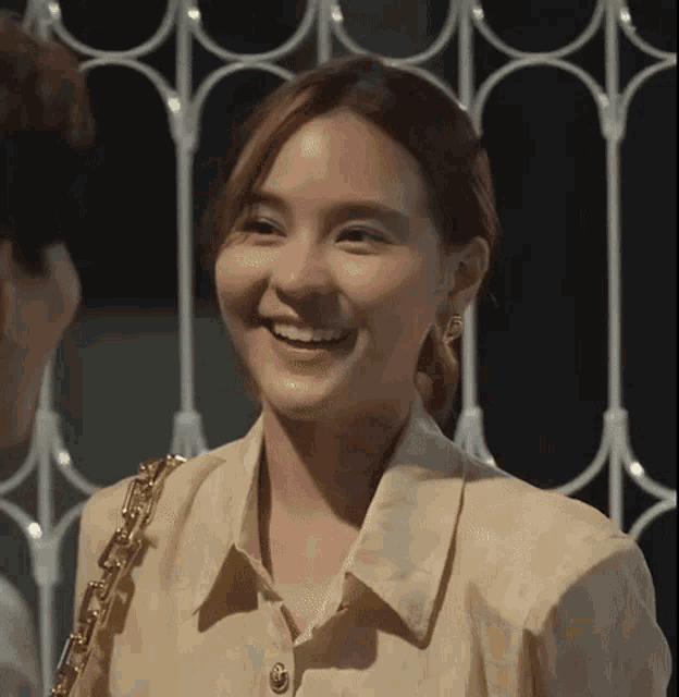 a woman in a white shirt is smiling and looking at a man .