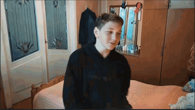 a young boy wearing a black sweatshirt with the word supreme on it