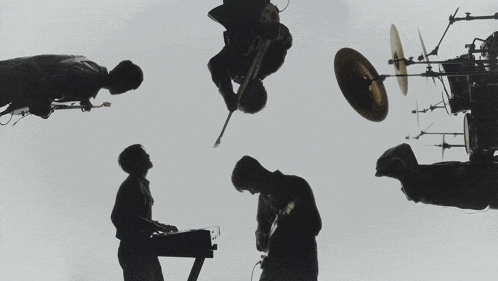 a silhouette of a man playing a guitar and a man playing a keyboard